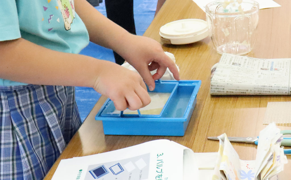 紙すき体験する小学生