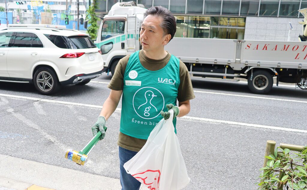 ごみ拾いをする大昭和紙工産業(株)齊藤社長