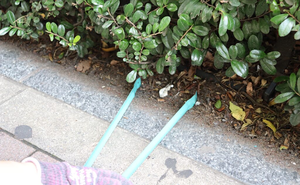 植え込みのごみを拾う様子