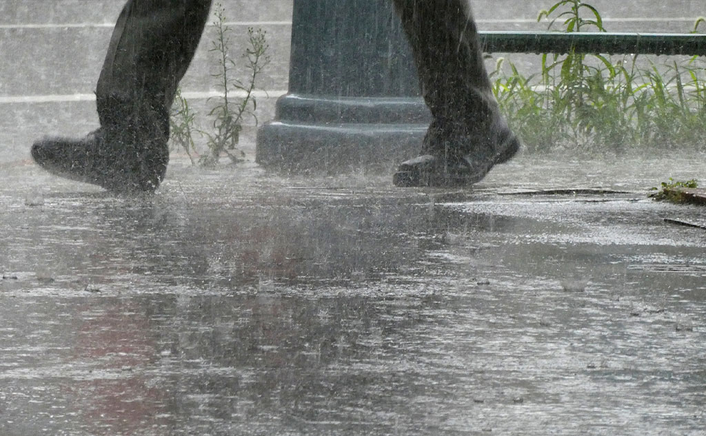 豪雨の街中を歩く人